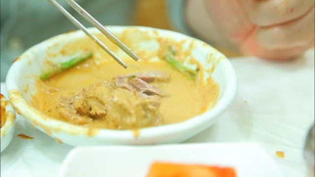 접시에 담긴 오리고기를 젓가락으로 집는 장면