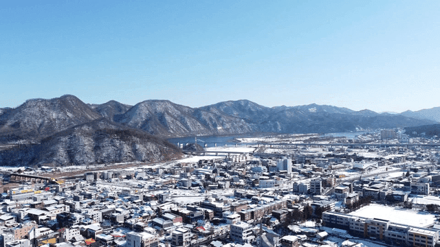 Snow-covered city with mountain backdrop