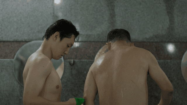 Two men scrubbing each other's backs in a bathhouse