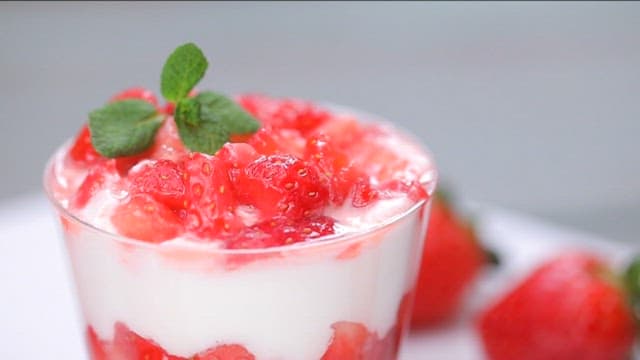 Spoonful of strawberry cream dessert with mint