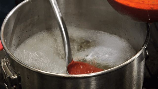 Red marinade being poured into a pot