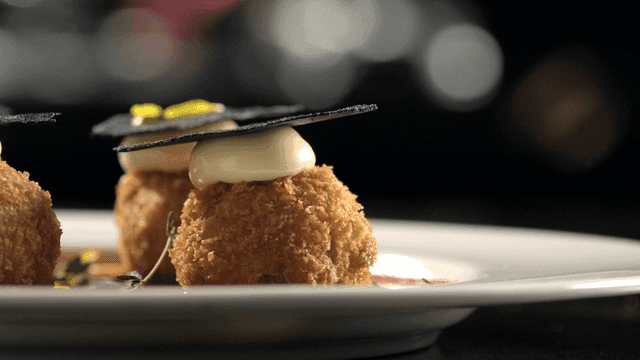 Croquettes topped with cream and truffle