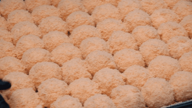 Pink rice cake being prepared on a tray