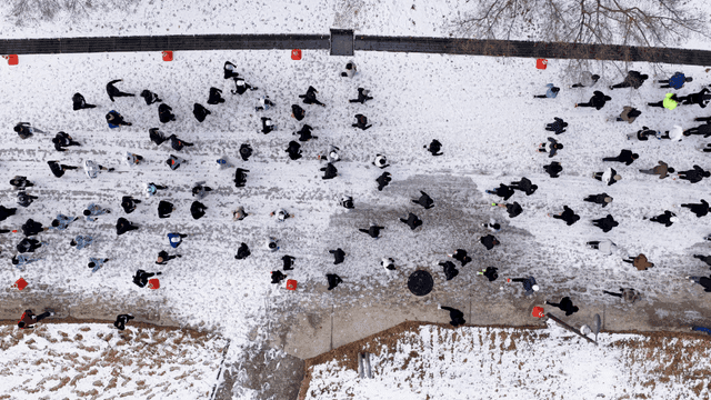 People running on snow-covered road in winter