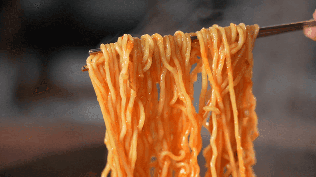 젓가락으로 집어든 부대찌개 라면