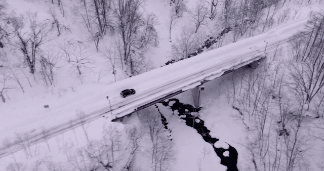 Car driving on a snowy forest road