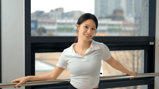 창가에서 정면을 보고 미소 짓는 젊은 여성