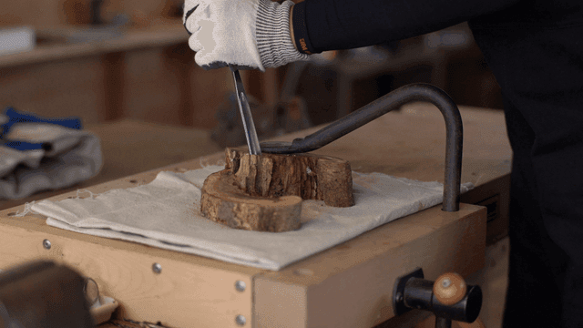 작업대에서 끌로 목공 작업하는 작업자