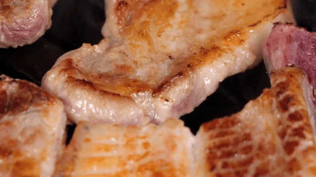 뜨거운 팬에서 구워지는 육즙 가득한 돼지고기