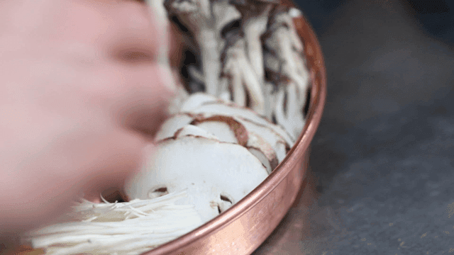 Mushrooms being prepared in a copper pot