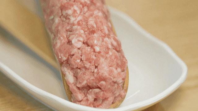 Raw minced meat on a wooden spoon