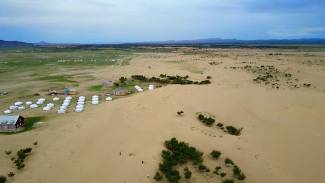 Vast desert landscape with yurts