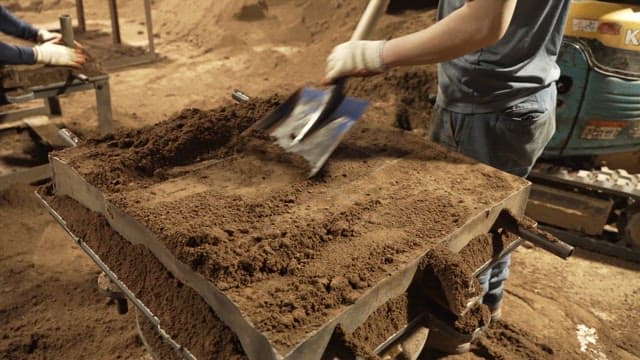 Workers shaping sand molds in a factory