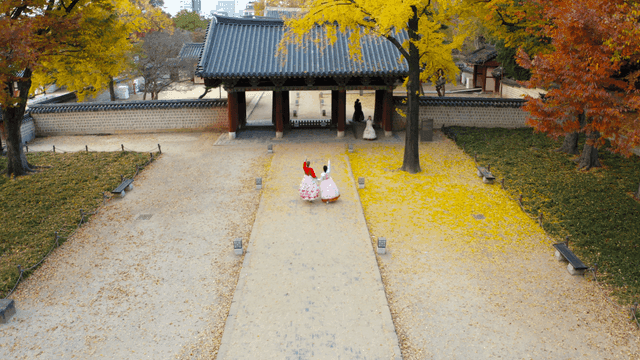 People in hanbok entering a traditional hanok gate
