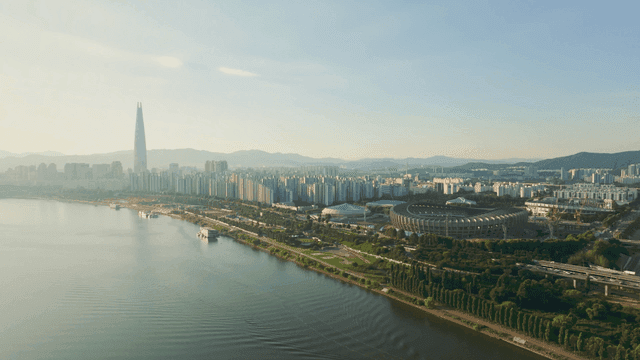 A cityscape with a river and stadium