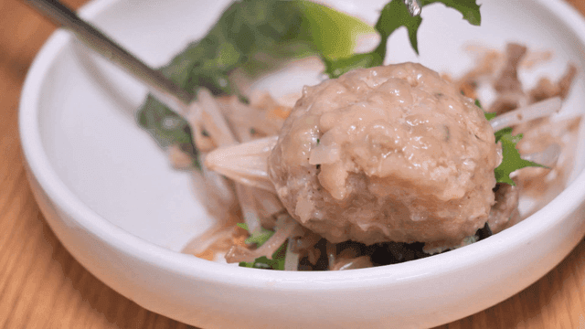 Chopsticks holding rolled dumplings on plate