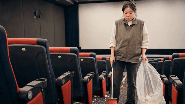 영화관을 청소하다 한숨을 쉬는 여성