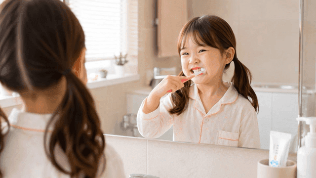 Girl brushing her teeth in bathroom