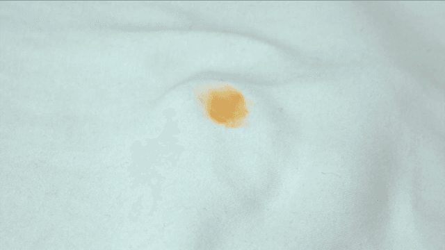 천에 있는 얼룩을 문지르는 손가락