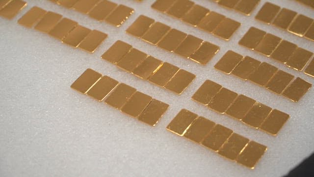 Gold plates arranged on a white surface