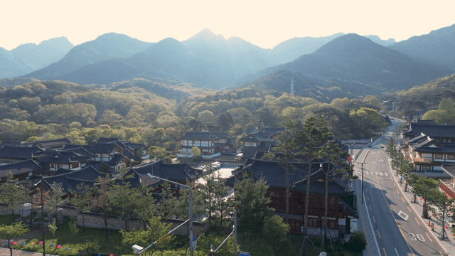 Hanok village surrounded by mountains under dazzling sun