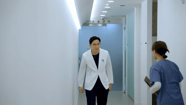 지친 모습으로 병원 복도를 걷는 의사