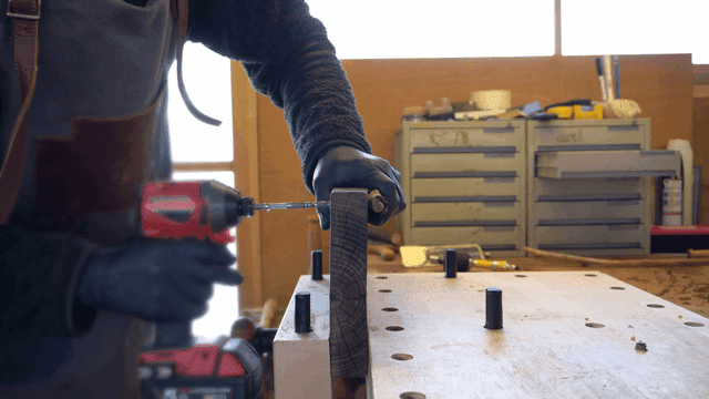 작업장에서 드릴을 사용하는 사람