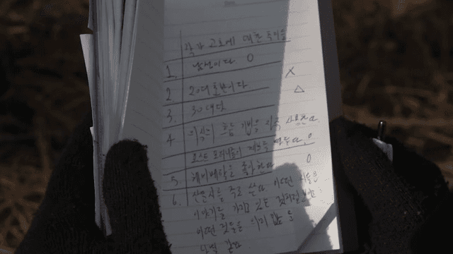 야외에서 노트를 살펴보는 사람