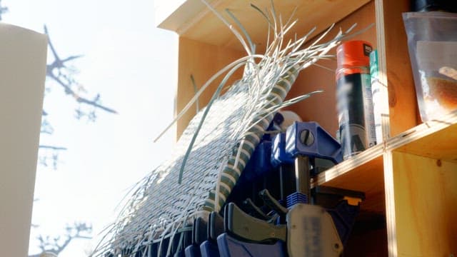 Various tools and wires organized on a wooden shelf