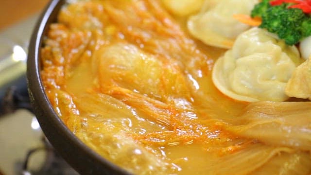 Braised aged kimchi and pork with dumplings and vegetables