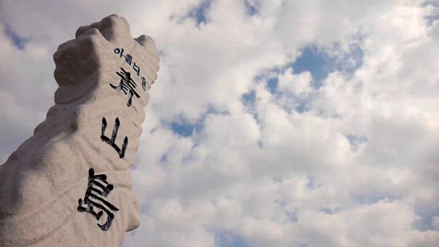 구름이 가득한 하늘 아래 세워진 비석