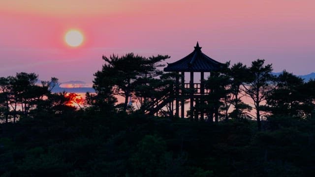 Sunset Seen through the Silhouettes of Trees and Pavilion