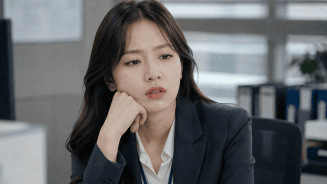 Woman resting her chin on her hand, lost in thought in office