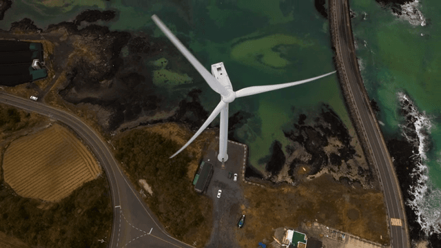 해안 도로 근처에서 회전하는 풍력 터빈