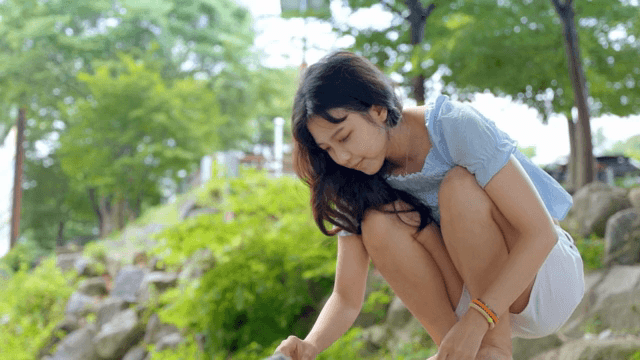 공원에서 쪼그리고 앉아 있는 여성