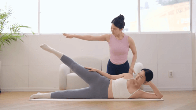 Yoga instructor guiding a student indoors