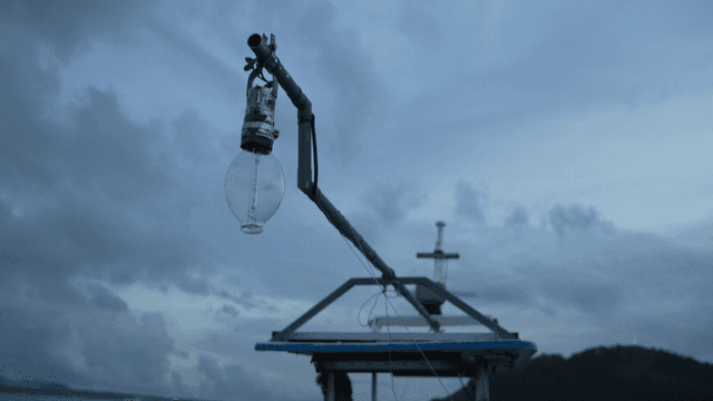 Fishing boat with a light bulb at dusk