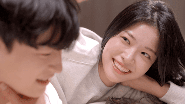 Couple resting on bed with gentle smiles