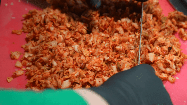 Kimchi chopped with knife on cutting board