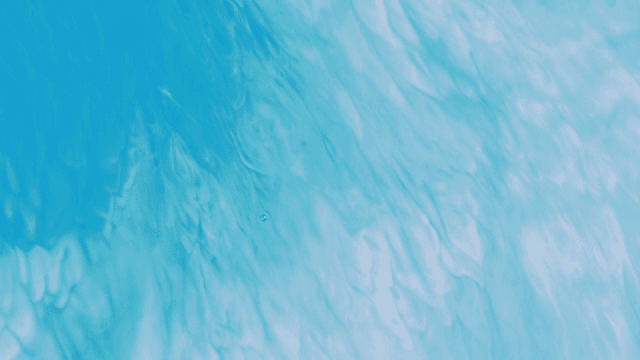 Abstract pattern of blue and white liquids mixing together