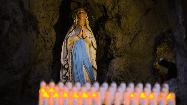 Statue of Mary in a cave with candles
