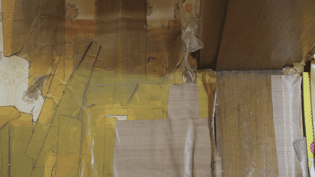 테이프로 붙인 벽지가 있는 방의 구석