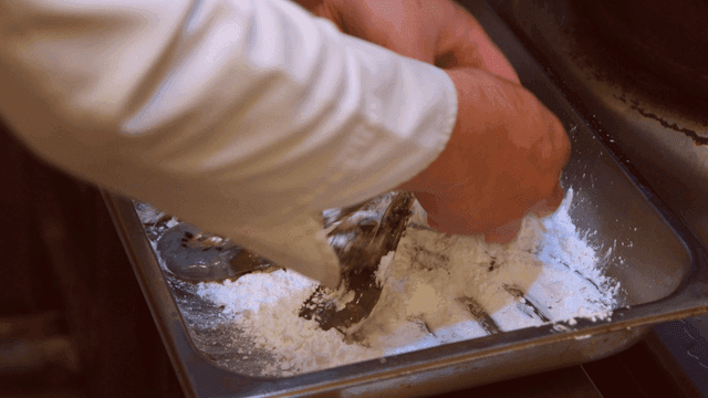 Chef coating shrimp in flour