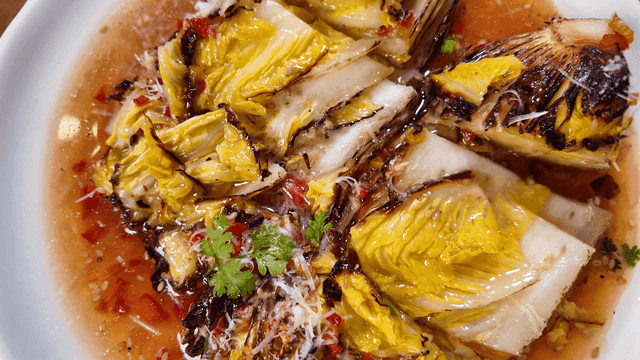 Roasted cabbage with sauce and herbs, dipped fork