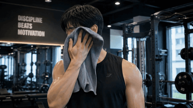 Man wiping sweat in a gym after workout