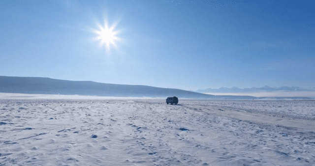 Vehicle traveling across a snowy landscape