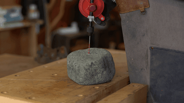작업대에서 돌을 드릴로 뚫는 장면
