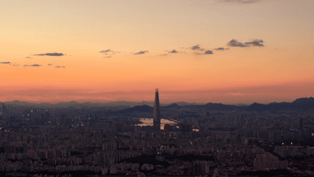 City skyline at sunset with a tall tower