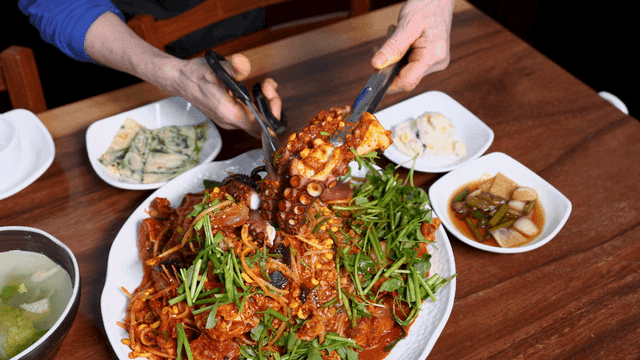 Tongs and scissors used to cut spicy octopus seafood stew