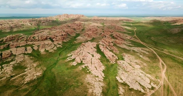 Expansive rocky landscape with green fields